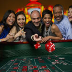 Excited friends gambling at craps table in casino